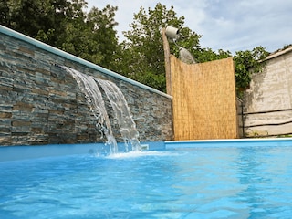 Luxuriöses Badeerlebnis mit einem sanften Wasserfall.