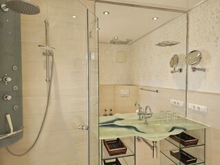 Badezimmer mit Deluxe-Dusche und Glas-Waschtisch