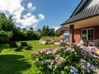 Sonnige Gartenterrasse mit Dünenwall