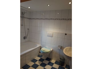 Badezimmer mit WC, Waschbecken und Badewanne