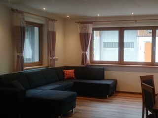 Wohn- und Essbereich mit TV und Ofen