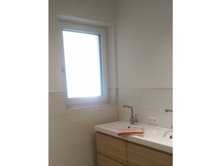 Badezimmer mit Doppelwaschbecken und Regendusche