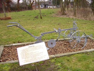 Kleiner Park mit alten Ackergeräten