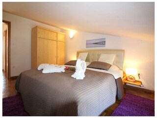 Schlafzimmer mit Bettwäsche & Doppelbett