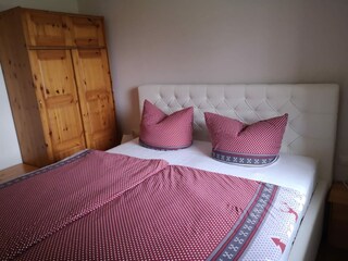 Schlafzimmer mit Doppelbett und Kleiderschrank