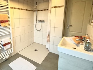 Badezimmer mit ebenerdiger Dusche und Fußbodenheizung