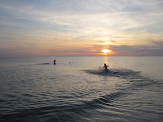 Baden im Meer bei Sonnenuntergang