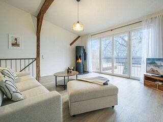 Wohnzimmer mit Couch, Kamin und Meerblick
