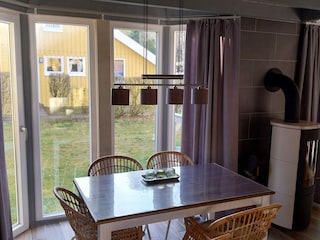 Esstisch mit Blick in den Garten und auf den Kamin