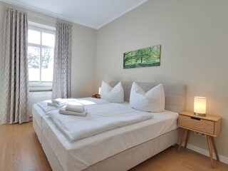 Schlafzimmer mit Doppelbett, TV und Kleiderständer