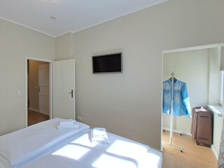 Schlafzimmer mit Doppelbett, TV und Kleiderständer