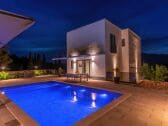 Rear view of house with pool at night