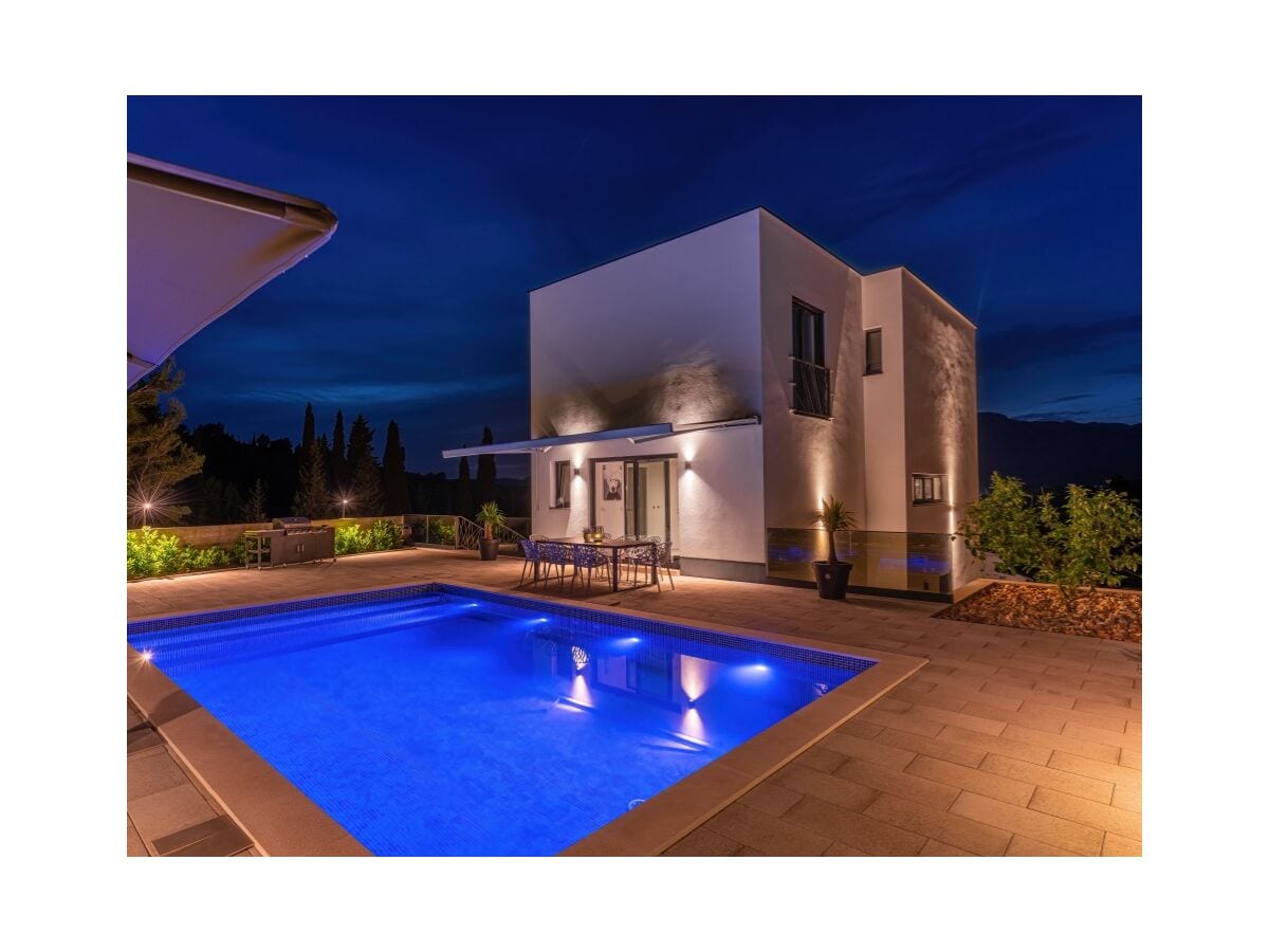 Rear view of house with pool at night