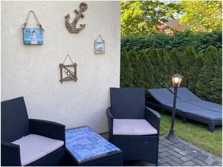 Terrasse mit kleinem Garten und Sonnenliegen