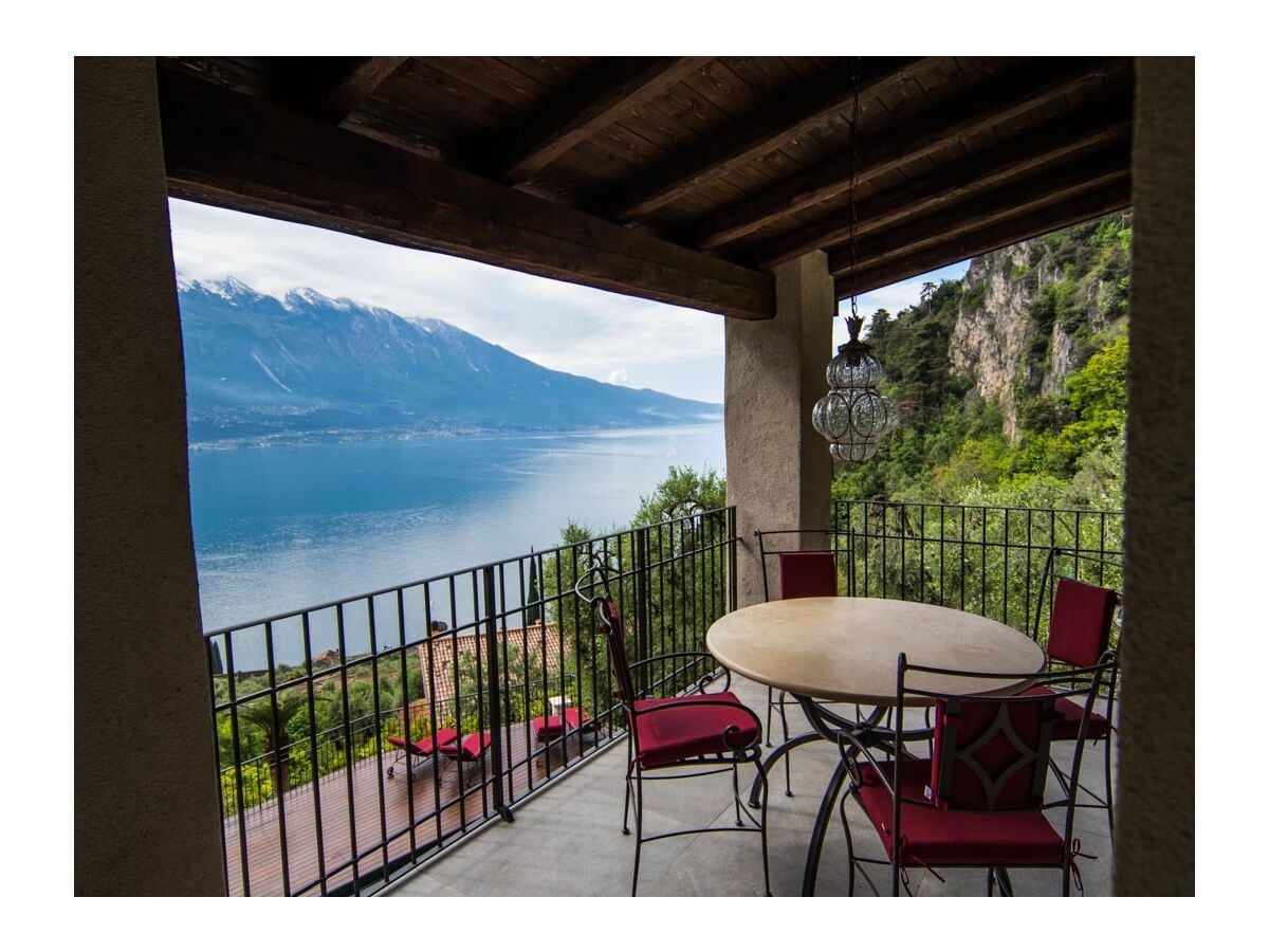 Überdachte Terrasse mit Esstisch und Sitzecke.