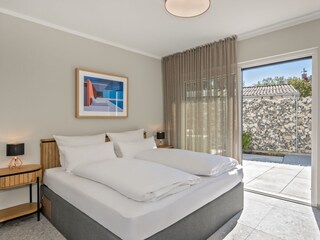 Schlafzimmer im Erdgeschoss mit Zugang zur Terrasse