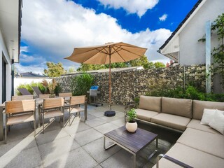 Terrasse mit Lounge, Esstisch, Liegestühlen und Grill