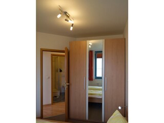 Schrank und die Tür vom Schlafzimmer auf den Flur der Ferienwohnung Inselblume 03 auf Fehmarn