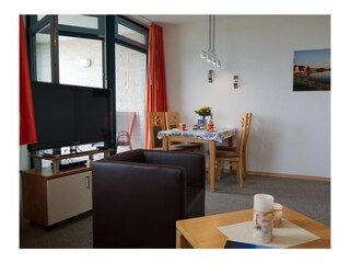 Blick auf den TV und Esstisch von der Couch der Ferienwohnung Inselblume 03 auf Fehmarn