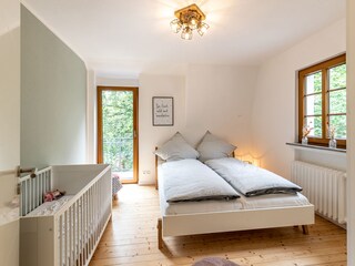 Schlafzimmer 3 mit Doppelbett und Kindergitterbett