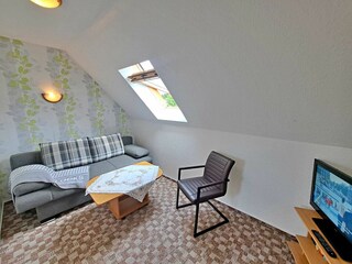 Wohnzimmer im 1. OG mit Couch (Schlaffunktion, Aufbettungsmöglichkeit für 2 weitere Personen), TV