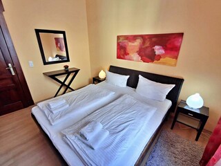 Schlafzimmer mit Doppelbett und Kleiderschrank