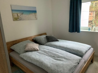 Das Schlafzimmer mit Doppelbett und Blick ins Grüne.