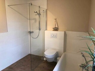 Badezimmer mit Wanne und Walk in Dusche im EG