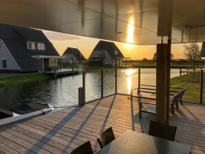 Holiday park Thatched villa with lounge set, right at the water - Delfstrahuizen - image1