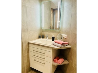 Waschbecken mit beleuchtetem Spiegel