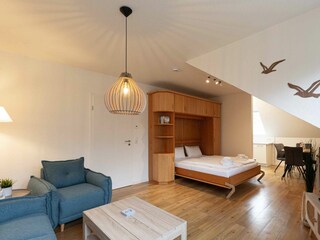 Wohnzimmer mit bequemem Schrank-Doppelbett