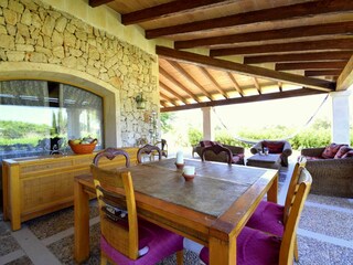 Überdachte Terrasse mit Esstisch und sitzecke