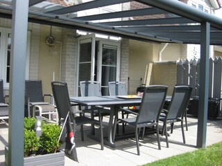 Terrasse mit einer Glasüberdachung und Markise