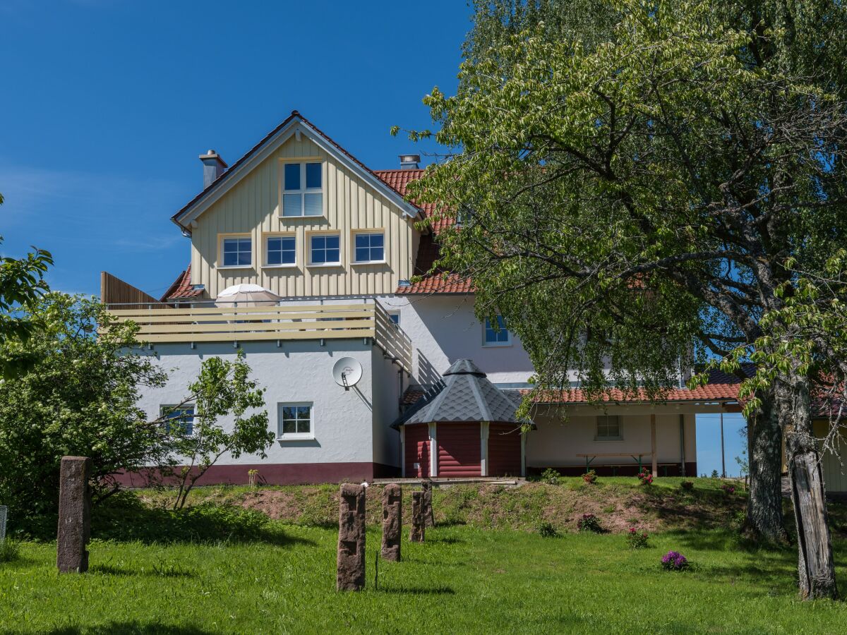 Blick vom Garten auf das Ferienhaus mit Aussensauna