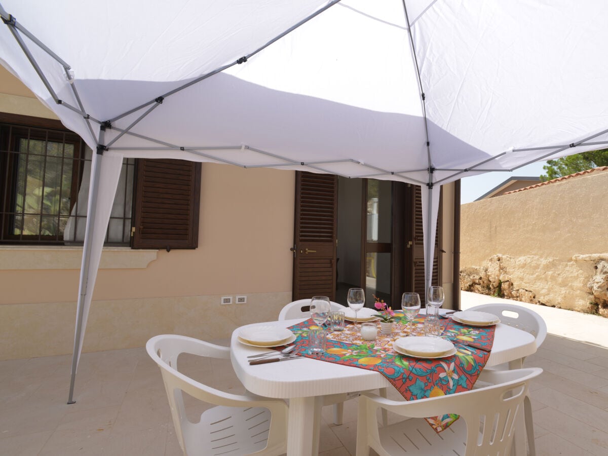 Terrasse mit Gazebo und Frühstückstisch.