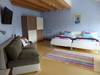 Schlafzimmer mit Sitzecke und TV-Gerät