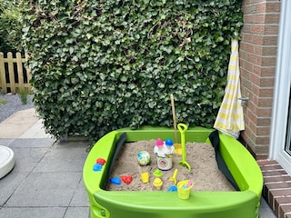 Sandkasten im eingezäuntem kleiner Garten