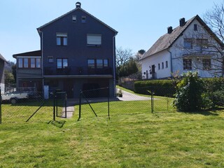 Wiese und Parkfläche hinter dem Haus