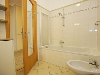 Badezimmer mit Badewanne und Waschmaschine