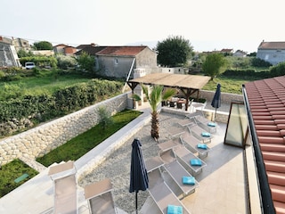 Blick vom Balkon auf den Garten und die Terrasse