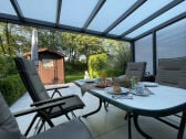 Überdachte Terrasse mit seitlichem Windschutz