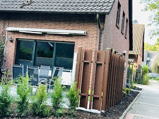 Terrasse mit Gartenmöbeln, Sonnenliegen und Markise