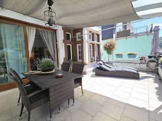 Großer Balkon mit Sonnenliegen und Wasserblick