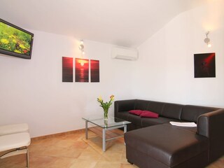 Wohnraumansicht mit Funktionssofa und Fernsehecke