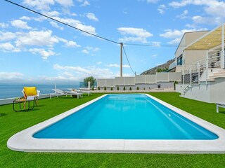 A sun deck area with artificial grass and with 4 deck c