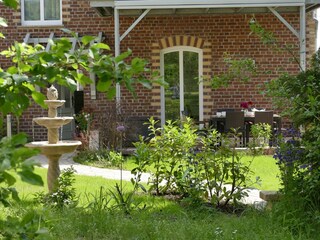 Blick in Garten und auf die Terrasse der Ferienwohnung
