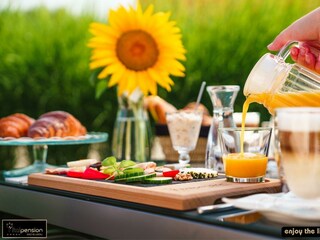 Frühstück Oranagensaft einschenken