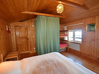 Schlafzimmer mit Doppelbett und Etagenbett