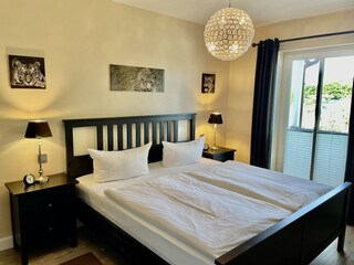 Schlafzimmer mit Doppelbett und Zugang Balkon
