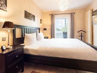 Schlafzimmer mit TV und Zugang Balkon